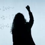 黒板で計算する女性で投資効果の計算をイメージ