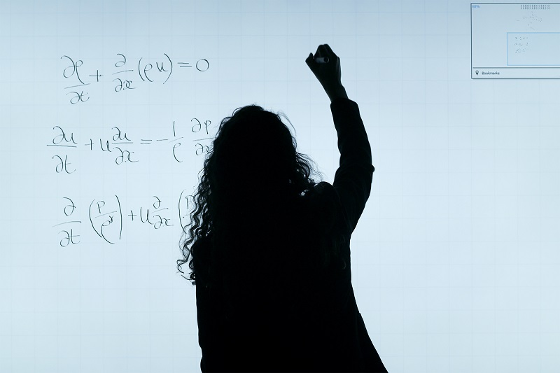 黒板で計算する女性で投資効果の計算をイメージ